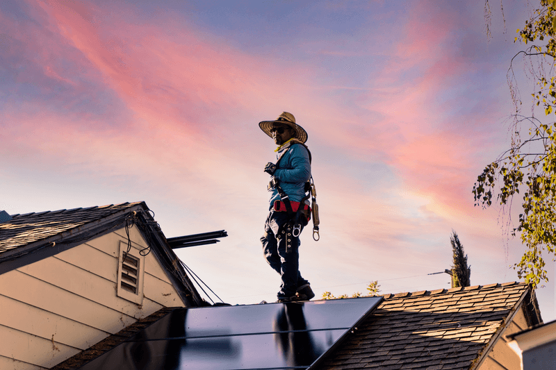 A man standing on a roof peacefully contemplating his existence